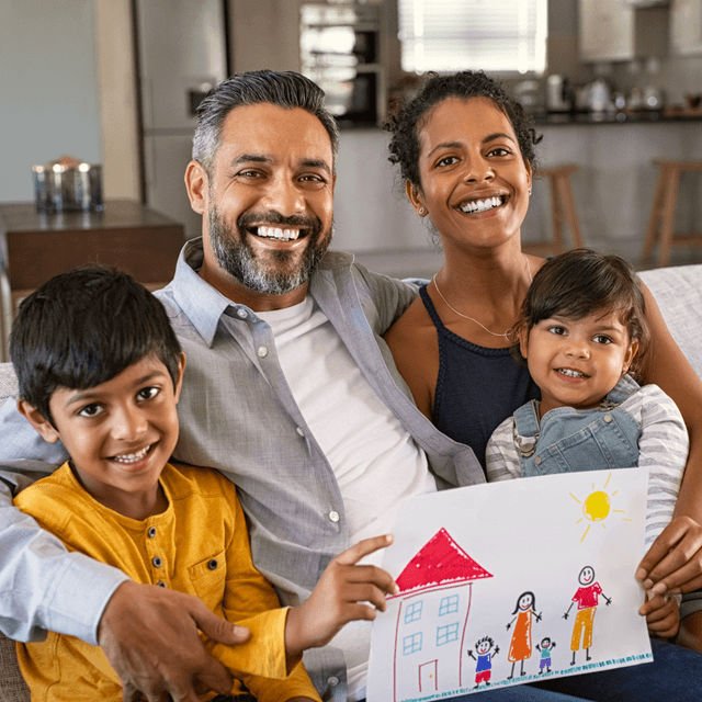 family of four holding a kid's drawing