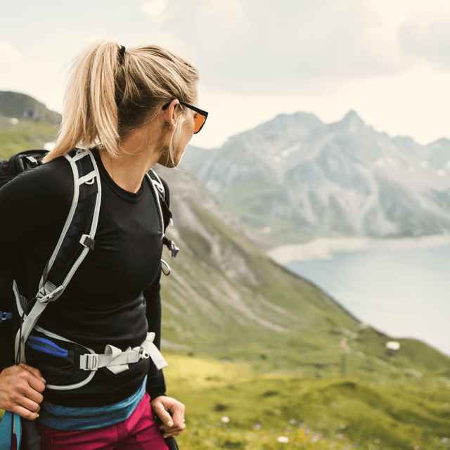 woman with a backpack looking at a lake
